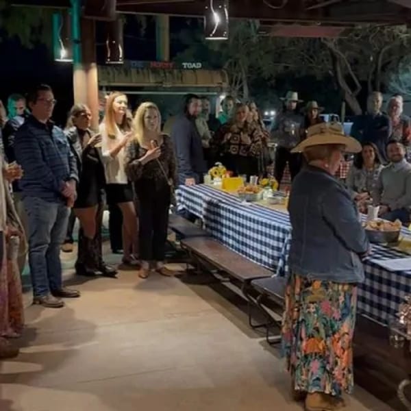 Guests gather around a long table with a blue and white checkered tablecloth at The Horny Toad.