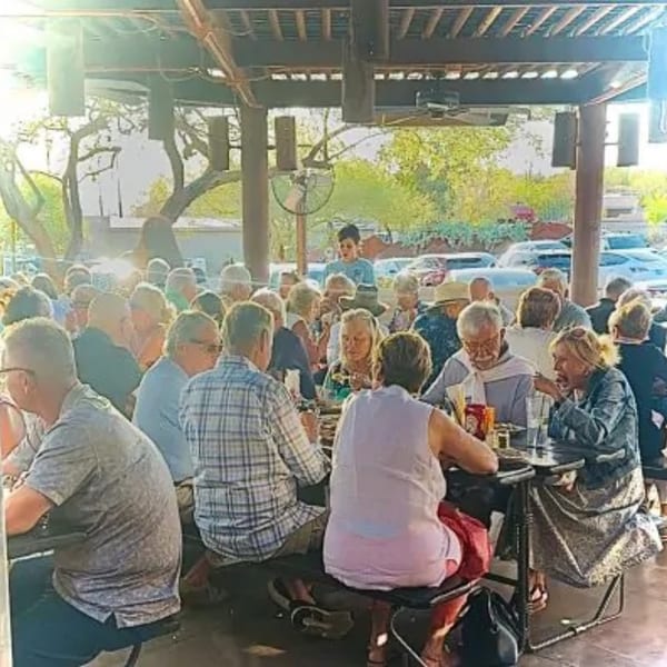Diners enjoying a meal on the outdoor patio of The Horny Toad restaurant on a sunny day.
