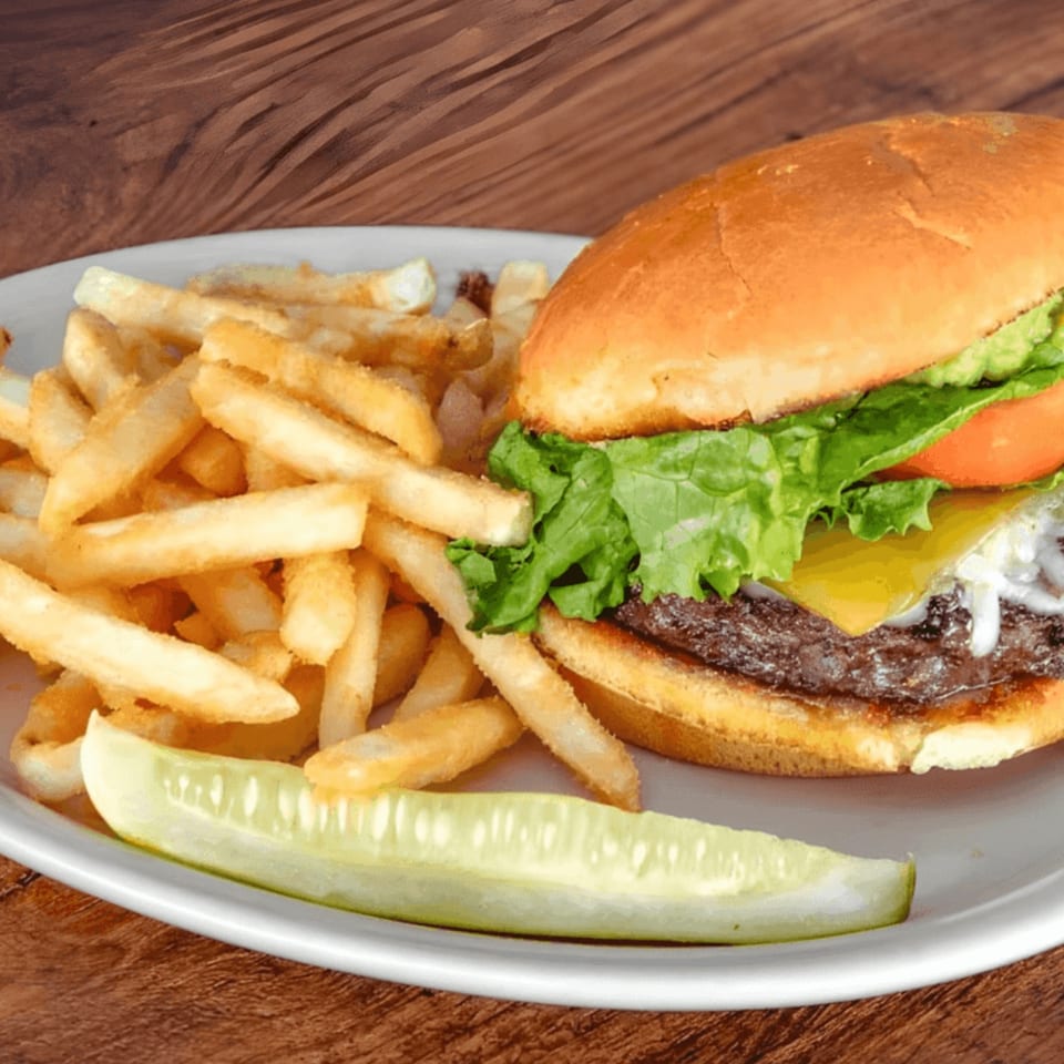 A Horny Toad cheeseburger with lettuce, tomato, and onion, served with fries and a pickle spear.